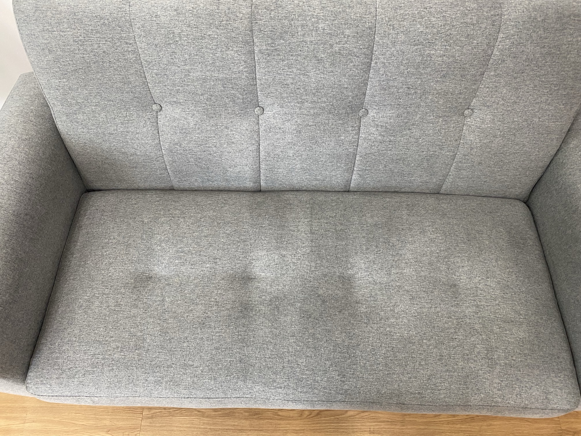Close-up of worn leather sofa armrest showing cracking and discolouration
