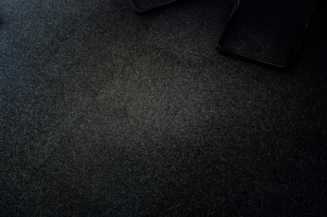 Dark, grainy texture with a glimpse of objects.